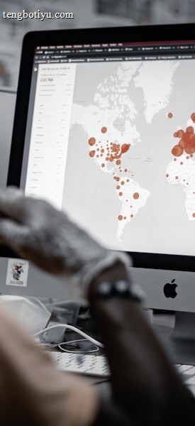 A person is viewing a map with red data points on a computer monitor, likely indicating a geographical distribution. The image has a focus on technology and data analysis.